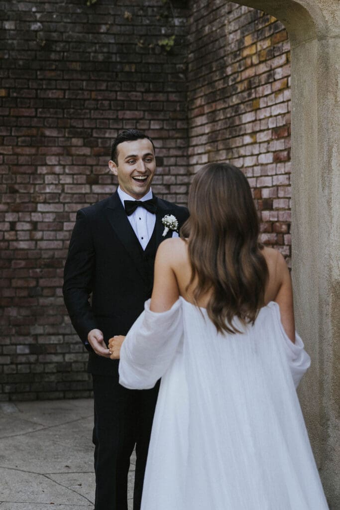 Groom smiling as he sees the bride during their wedding day first look in Washington.