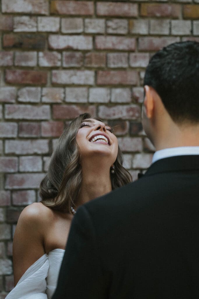 Bride laughing with the groom during their candid wedding day first look in Washington.