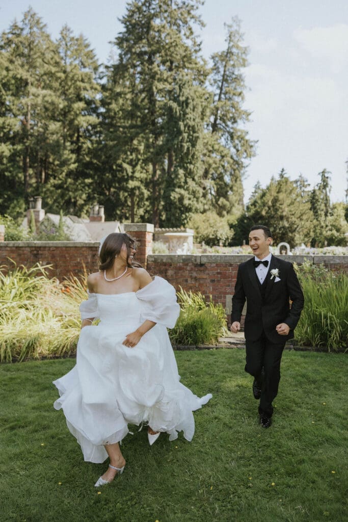 Bride and groom running through the garden together after their outdoor Washington estate wedding ceremony.