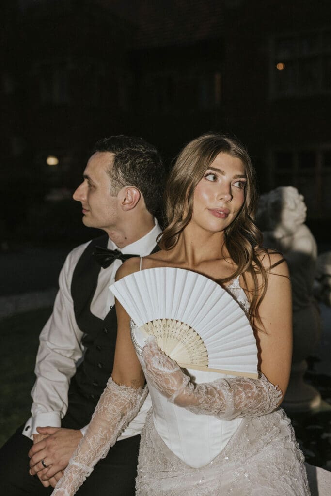Bride and groom posing by an outdoor fountain at night during their elegant Washington estate wedding reception.